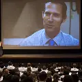 Crowd watches a presentation on a large projector screen