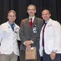 Three people pose for a photo